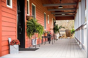 Arborwall Solid Cedar Homes have clapboard-style exteriors and broad porch spaces