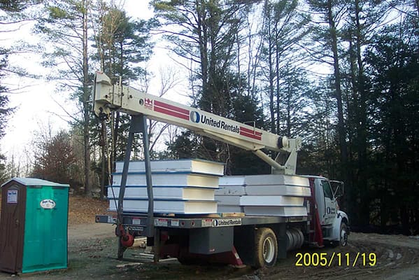 Structurally insulated panels being delivered by a truck.