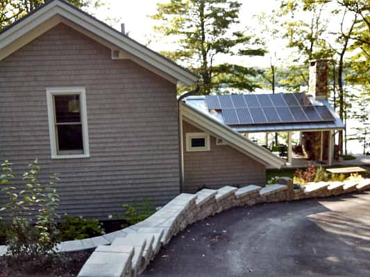 Sun room with solar panels on the roof viewed from driveway